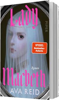 Das Buchcover zeigt ein oval gerahmtes Spiegelbild einer blassen, jungen Frau mit durchsichtigem weißen Schleier und großen dunklen Augen vor dunklem Hintergrund, melancholisch und unheimlich wirkend. Der Titel „Lady Macbeth“ steht groß in leuchtendem Pink in gotisch anmutender Schrift, unten der Autorenname AVA REID in weißer Versalschrift, dazu klein das Wort „Roman“. Rechts ein orange-roter Button mit der Aufschrift „SPIEGEL Bestseller-Autorin“.