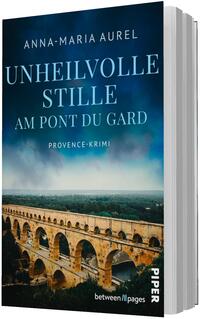 Das Buchcover zeigt die römische Aquäduktbrücke Pont du Gard im Vordergrund, ihr warmgoldener Sandstein kontrastiert mit einem dunkelblau bis türkisen Himmel und grüner Landschaft. Der Titel „Unheilvolle Stille“ erscheint groß in weißen Versalien, darunter „Am Pont du Gard“ und die Genrebezeichnung „Provence‑Krimi“. Oben steht der Autorenname Anna‑Maria Aurel. Die Komposition und Farbgebung vermitteln eine düstere, spannungsgeladene Atmosphäre.