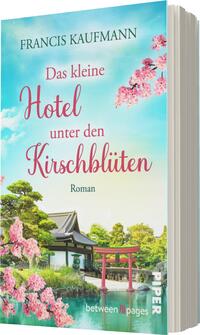 Das Buchcover zeigt einen idyllischen Landschaftshorizont mit einem traditionellen Gebäude und üppigem Grün. Die obere Hälfte ist in einem sanften Blau gehalten, während die untere Hälfte von blühenden Kirschbäumen in zarten Rosa- und Weißtönen dominiert wird. Der Titel „Das kleine Hotel unter den Kirschblüten“ ist in eleganter, geschwungener Schrift in kräftigem Pink platziert, und darunter steht das Wort „Roman“ in schlichter Schrift. Der Autorname „Francis Kaufmann“ erscheint darüber in dezentem Schwarz.
