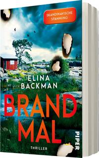 Das Buchcover zeigt eine dramatische Landschaft mit einem ruhigen See und einer roten Holzhütte, umgeben von üppigem Grün und Felsen. Der Himmel ist dunkel und wolkig, was eine spannungsgeladene Atmosphäre vermittelt. Der Titel „BRANDMAL“ erscheint in großen, leuchtend roten Buchstaben, während der Name der Autorin „Elina Backman“ in weißer Schrift darunter platziert ist. Oben rechts befindet sich ein rotes Rechteck mit der Aufschrift „SKANDINAVISCHE SPANNUNG“. Das Cover vermittelt die Stimmung eines Thrillers.