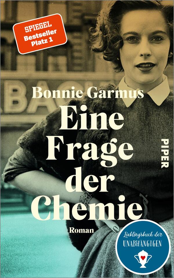 Das Buchcover zeigt eine Frau mit vintage-inspirierter Frisur und einem weißen Kragen. Der Hintergrund ist in gedämpften Farbtönen gehalten, was eine nostalgische Atmosphäre vermittelt. Der Titel „Eine Frage der Chemie“ ist in großen, weißen Buchstaben platziert, während der Autorinnenname „Bonnie Garmus“ oben in elegantem Schwarz steht. In der oberen linken Ecke befindet sich ein rotes Label mit der Aufschrift „SPIEGEL Bestseller Platz 1“. Das Cover vermittelt einen Eindruck von zeitloser Eleganz und einem spannenden literarischen Inhalt.