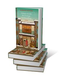 Bücherstapel des Buches „Schnee vor der Freitagsbuchhandlung“