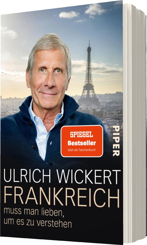Das Buchcover zeigt einen älteren Mann mit grauen Haaren und freundlichem Ausdruck, der vor einer verschwommenen Stadtansicht von Paris steht, mit dem Eiffelturm im Hintergrund. Der obere Teil des Covers ist in sanften, hellen Farbtönen gehalten, während der Titel „FRANKREICH“ in großen, weißen Buchstaben über einem schwarzen Hintergrund präsent ist. Darunter steht der Untertitel „muss man lieben, um es zu verstehen“ in kleinerer Schrift. Am oberen Rand befindet sich ein rotes „SPIEGEL Bestseller“-Label.
