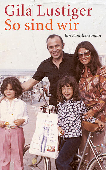 Das Buchcover zeigt eine nostalgische Familienaufnahme, die in warmen Farben gehalten ist. Im Vordergrund stehen zwei Kinder und ein Mann mit dunklem Haar, der einen freundlichen Gesichtsausdruck zeigt. Eine Frau mit langen, lockigen Haaren steht neben ihm. Alle sind lächelnd, vielschichtig und tragen legere Kleidung. Der Titel „So sind wir“ sowie der Autorname „Gila Lustiger“ sind prominent in großen, roten Buchstaben platziert, während „Ein Familienroman“ in kleinerer, schwarzer Schrift darunter steht.