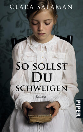 Das Buchcover zeigt ein nachdenkliches Mädchen in einem weißen, rüschenbesetzten Kleid, das auf einem Stuhl sitzt. Ihr Blick ist auf ein altes Buch in ihren Händen gerichtet. Im Hintergrund sind zarte, graue Blumendekorationen zu sehen, die eine melancholische Atmosphäre erzeugen. Der Titel „So sollst Du schweigen“ ist in großer, schwarzer Schrift prominent platziert, gefolgt von dem Zusatz „Roman“ in kleinerer Schrift. Der Name der Autorin, Clara Salaman, steht oberhalb des Titels.