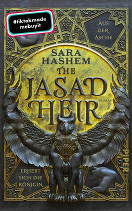 The Jasad Heir Das Buchcover zeigt einen goldenen Hintergrund mit wertvollen, glänzenden Verzierungen. Im oberen Bereich steht in eleganter, schwarzer Schrift „Sara Hashem“ und darunter in großen, schwarzen Buchstaben „THE JASAD HEIR“. Ein majestätischer Greif mit weit ausgebreiteten Flügeln ist im unteren Teil des Covers abgebildet. Der Titel wird von geschwungenen Ornamenten umrahmt. In der oberen linken Ecke befindet sich ein auffälliger, farbiger Hashtag. Am unteren Rand ist das Verlagslogo „PIPER“ zu sehen.