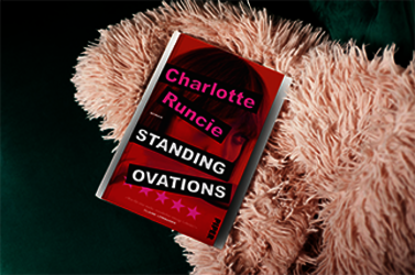 Das Buch "Standing Ovations" von Charlotte Runcie liegt auf einem flauschigen Kissen.