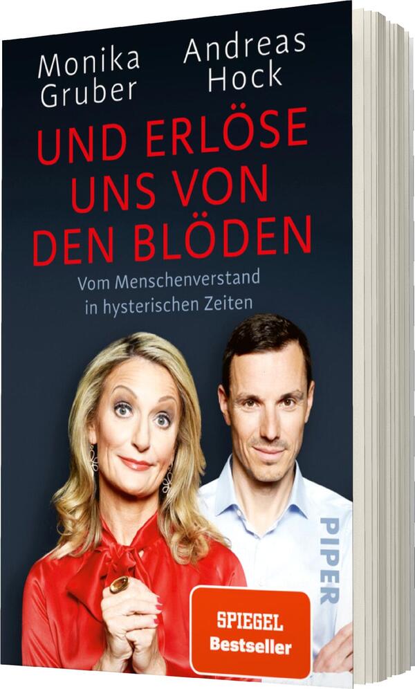 Das Buchcover zeigt eine Frontalansicht der beiden Autoren Monika Gruber und Andreas Hock. Monika Gruber, mit heller Blonden Haarfarbe und rotem Oberteil, blickt mit einem humorvollen Ausdruck in die Kamera, während sie die Hand an ihr Kinn legt. Andreas Hock steht neben ihr in einem weißen Hemd und hat einen neutralen Gesichtsausdruck. Der Titel „UND ERLÖSE UNS VON DEN BLÖDEN“ hebt sich in großen, roten Buchstaben auf dunkelblauem Hintergrund ab. Unter dem Titel steht der Untertitel „Vom Menschenverstand in hysterischen Zeiten“. Unten auf dem Cover befindet sich der Hinweis „SPIEGEL Bestseller“ in einem weißen Kasten, das Verlagslogo ist in der Ecke sichtbar.