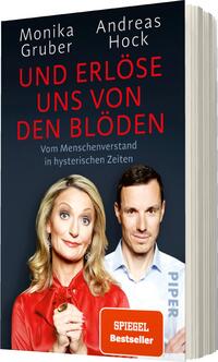 Das Buchcover zeigt eine Frontalansicht der beiden Autoren Monika Gruber und Andreas Hock. Monika Gruber, mit heller Blonden Haarfarbe und rotem Oberteil, blickt mit einem humorvollen Ausdruck in die Kamera, während sie die Hand an ihr Kinn legt. Andreas Hock steht neben ihr in einem weißen Hemd und hat einen neutralen Gesichtsausdruck. Der Titel „UND ERLÖSE UNS VON DEN BLÖDEN“ hebt sich in großen, roten Buchstaben auf dunkelblauem Hintergrund ab. Unter dem Titel steht der Untertitel „Vom Menschenverstand in hysterischen Zeiten“. Unten auf dem Cover befindet sich der Hinweis „SPIEGEL Bestseller“ in einem weißen Kasten, das Verlagslogo ist in der Ecke sichtbar.