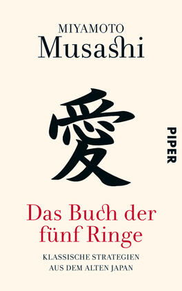 Das Buchcover zeigt einen hellen, cremigen Hintergrund. Oben steht der Autorname „Miyamoto Musashi“ in schwarzer Schrift, gefolgt von einem großen, künstlerisch gestalteten Schriftzeichen in Schwarz, das die Bedeutung „Liebe“ trägt. Darunter befindet sich der Titel „Das Buch der fünf Ringe“ in roter, gut lesbarer Schrift. Am unteren Rand wird der Untertitel „klassische Strategien aus dem alten Japan“ in kleinerer, schwarzer Schrift präsentiert. Die Gestaltung vermittelt eine elegante und traditionelle Atmosphäre.
