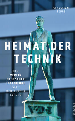 Heimat der Technik Das Buchcover zeigt eine patinagrüne Bronzestatue eines stehenden Mannes auf einem Sockel mit der Inschrift VDI vor einer unscharfen blau-grauen Glasfassade. Über der Figur prangt der Titel in großen weißen serifenlosen Großbuchstaben „HEIMAT DER TECHNIK“. Links steht die Unterzeile „Der Verein Deutscher Ingenieure seit den 1970er Jahren“. Oben rechts ist der Autorenname Sebastian Teupe. Die Stimmung wirkt nüchtern und institutional.
