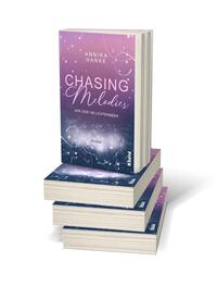 Bücherstapel des Buches „Chasing Melodies – Wir zwei im Lichtermeer“