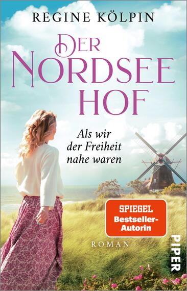 Das Buchcover zeigt eine Landschaft an der Nordsee mit einem weißen Mühlenrad im Hintergrund. Im Vordergrund steht eine Frau mit langen, lockigen Haaren, die in ein fließendes, helles Kleid gekleidet ist. Ihre Pose vermittelt einen Gefühl von Freiheit. Die Farben sind hell und freundlich, mit blauen und grünen Tönen, die eine harmonische Atmosphäre schaffen. Der Titel „Der Nordsee Hof“ ist in großen, geschwungenen lila Buchstaben oben platziert, darunter steht der Untertitel „Als wir der Freiheit nahe waren'. Der Name der Autorin, Regine Kölpin, erscheint ebenfalls in einer klaren Schrift. Ein rotes Feld am unteren Rand weist darauf hin, dass die Autorin „SPIEGEL Bestseller-Autorin“ ist.