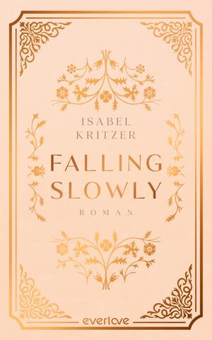 Das Buchcover zeigt einen zarten, rosafarbenen Hintergrund. In der Mitte ist der Titel „FALLING SLOWLY“ in großen, glänzenden, goldenen Buchstaben platziert, darunter steht der Zusatz „Roman“ in einer kleineren Schrift. Oben und unten verzieren filigrane floral anmutende Ornamente das Cover, ebenfalls in Gold. Der Name der Autorin „ISABEL KRITZER“ befindet sich in eleganter, goldener Schrift oberhalb des Titels.