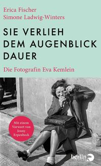 Das Buchcover zeigt im oberen Drittel ein mintgrünes Feld mit dem großen, schwarzen, serifenlosen Titel in Versalien „SIE VERLIEH DEM AUGENBLICK DAUER“; links oben stehen in roter Serifenschrift die Autorennamen Erica Fischer und Simone Ladwig-Winters, darunter in kleiner roter Serifenschrift der Untertitel Die Fotografin Eva Kemlein. Die untere Hälfte zeigt ein schwarzweißes Foto einer lächelnden Frau, die mit einer Kamera auf dem Gehsteig sitzt; Atmosphäre: nostalgisch, dokumentarisch.