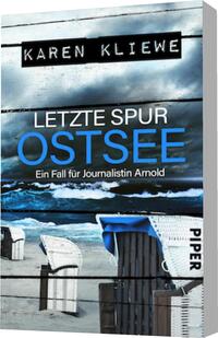 Das Buchcover zeigt einen düsteren Strand bei bewölktem Himmel. Im Vordergrund stehen zwei weiße Strandstühle, ein blauer Stuhl und Küstenwasser, das sanft an den Strand rollt. Der Titel „LETZTE SPUR OSTSEE“ ist in großer, blauer Schrift platziert, während der Untertitel „Ein Fall für Journalistin Arnold“ in kleinerer Schrift darunter steht. Der Name der Autorin, Karen Kliewe, ist oben auf dem Cover in schwarzer Schrift hervorgehoben. Die Gesamtatmosphäre vermittelt ein Gefühl von Mysterie und Spannung.