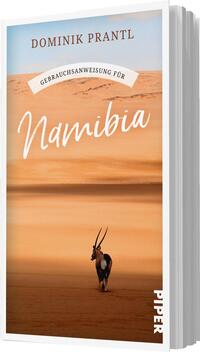 Das Buchcover zeigt eine weite, sandfarbene Dünenlandschaft Namibias unter einem blauen Himmel. Im Vordergrund ist ein einzelnes Antilope, das majestätisch zwischen den Dünen steht. Der Titel „Namibia“ ist in großen, geschwungenen, weißen Buchstaben dargestellt, während der Untertitel „Gebrauchsanweisung für“ in einer schmaleren Schriftart oben verläuft. Der Autorenname „Dominik Prantl“ ist kräftig in Schwarz am oberen Rand platziert. Die Farbgebung vermittelt eine warme, einladende Atmosphäre.