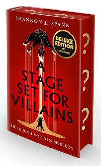 Das Buchcover zeigt ein tiefrotes Cover mit zentralem, stilisiertem gold‑schwarzem Vorhang/Hand‑Motiv, aus dem dünne Fäden herabhängen und zwei kleine schwarze Figuren am unteren Rand. Großflächiger Titel „A STAGE SET FOR VILLAINS“ in schwarzen Großbuchstaben, Autorname „Shannon J. Spann“ oben, Untertitel „HÜTE DICH VOR DEN SPIELERN“ unten. Rechts goldene Fragezeichen am Buchrücken. Runder Aufkleber mit Text „DELUXE EDITION MIT FARBSCHNITT“. Insgesamt düster und bedrohlich.