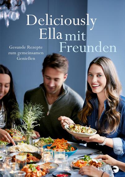 Das Buchcover zeigt eine fröhliche Gruppe junger Erwachsener, die um einen Tisch mit vielfältigen, gesunden Gerichten versammelt sind. Die Atmosphäre ist einladend und gesellig. Im Hintergrund ist eine hellblaue Wand zu sehen, die das Cover auflockert. Der Titel „Deliciously Ella mit Freunden“ ist in eleganter, weißer Typografie oben platziert, während der Untertitel „Gesunde Rezepte zum gemeinsamen Genießen“ in kleinerer Schrift darunter steht.