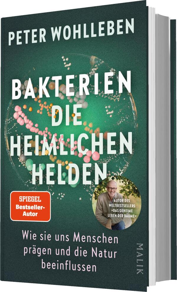 Das Buchcover zeigt einen grünen Hintergrund, auf dem bunte Bakterienstrukturen in verschiedenen Größen abgebildet sind. In großen, weißen Lettern steht der Titel „BAKTERIEN DIE HEIMLICHEN HELDEN“ zentral platziert. Darunter befindet sich der Untertitel „Wie sie uns Menschen prägen und die Natur beeinflussen“ in einer kleineren Schriftgröße. Oben links ist der Name des Autors, Peter Wohlleben, zu sehen. Ein Oranger Kreis mit dem Text „SPIEGEL Bestseller-Autor“ hebt sich deutlich ab.