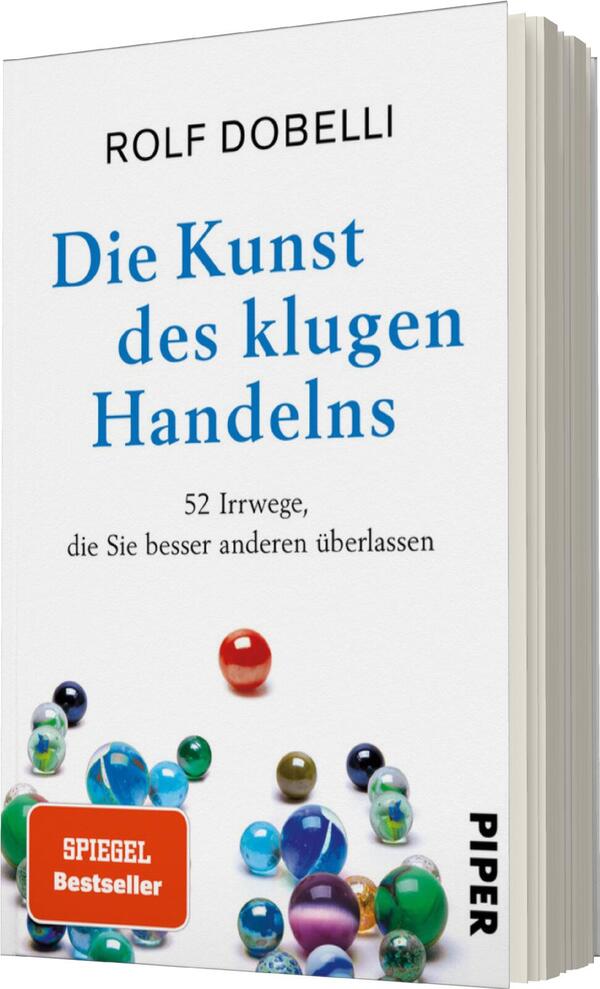 Das Buchcover zeigt einen weißen Hintergrund mit dem Titel „Die Kunst des klugen Handelns“ in auffälliger, blauer Schrift. Darunter steht der Untertitel „52 Irrwege, die Sie besser anderen überlassen“ in kleinerer, schwarzer Schrift. Am unteren Rand befindet sich ein rotes Kästchen mit dem Text „SPIEGEL Bestseller“ in weißer Schrift. Verschiedene bunte Murmeln sind am unteren Rand des Covers angeordnet, was eine spielerische Atmosphäre vermittelt. Der Autor Rolf Dobelli ist am oberen Rand in schwarzer Schrift genannt.