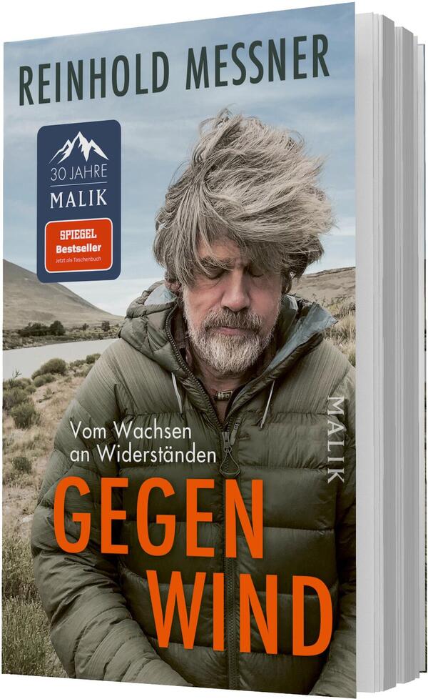 Das Buchcover zeigt ein Portrait von Reinhold Messner, der mit zerzaustem grauen Haar in einem grünen Jacket vor einer landschaftlichen Kulisse steht. Der Hintergrund ist von sanften Hügeln und einem Gewässer geprägt, was eine ruhige, aber dennoch kraftvolle Atmosphäre schafft. Der Titel „GEGEN WIND“ ist in auffälligem Orange platziert, während der Untertitel „Vom Wachsen an Widerständen“ in kleinerer Schrift erscheint. Oben links ist der Hinweis „SPIEGEL Bestseller“ in einem roten Rechteck abgedruckt.