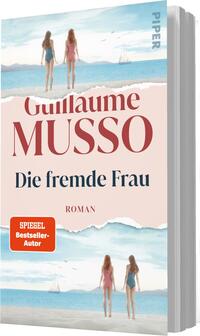 Das Buchcover zeigt zwei Frauen in Bademode, die am Strand stehen und auf das Wasser blicken. Der Hintergrund ist in sanften Blau- und Sandtönen gehalten, vermittelt eine sommerliche, entspannte Atmosphäre. Der Titel „Die fremde Frau“ ist in eleganter, blauer Schrift deutlich sichtbar, während der Autor „Guillaume Musso“ in einer kräftigen, rotbraunen Schrift darüber steht. Unten links befindet sich ein orangefarbener Button mit dem Text „SPIEGEL Bestseller-Autor“.