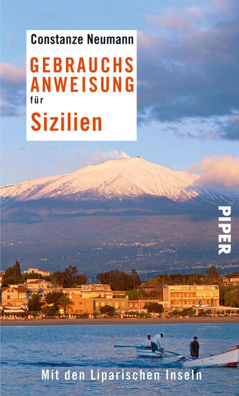 Das Buchcover zeigt eine malerische Küstenlandschaft mit dem Ätna im Hintergrund, der leicht mit Wolken bedeckt ist. Die Farbpalette umfasst sanfte Blau- und Orangetöne, die eine ruhige, einladende Atmosphäre schaffen. Im oberen Bereich ist der Titel „GEBRAUCHSANWEISUNG für Sizilien“ in auffälligem Orange platziert, während der Autor „Constanze Neumann“ darüber in Weiß steht. In der unteren Ecke findet sich der Hinweis „Mit den Liparischen Inseln“. Das Verlagslogo „PIPER“ ist an der rechten Seite abgebildet.