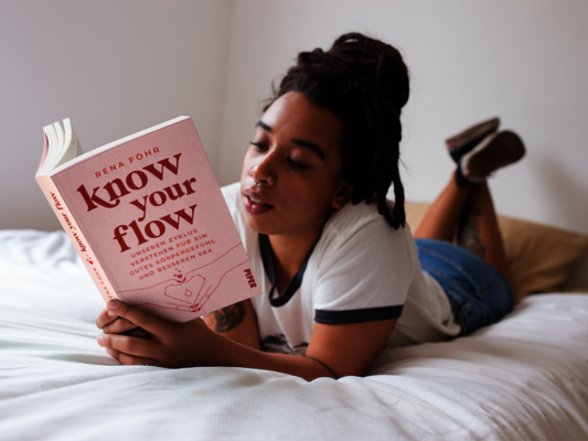 Dunkelhäutige Frau liest Rena Föhrs „Know your Flow“