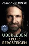 Das Buchcover zeigt ein dunkles, dramatisch beleuchtetes Porträt eines bärtigen Mannes mit langen Haaren und direktem Blick. Oben steht in Großbuchstaben der Autorenname Alexander Huber in weißer, serifenloser Schrift; darunter der Titel „ÜBERLEBEN TROTZ BERGSTEIGEN“ in zwei Farbtönen (mintgrün für „ÜBERLEBEN“, beige für „TROTZ BERGSTEIGEN“). Gesamtwirkung: ernst, entschlossen, zurückhaltende Farbpalette mit schwarzem Hintergrund.