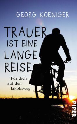 Das Buchcover zeigt eine silhouettenhafte Figur auf einem Fahrrad, die in die weite Landschaft fährt, während die Sonne tief am Horizont steht. Der Titel „TRAUER IST EINE LANGE REISE“ steht in großen, handschriftlichen Buchstaben in Weiß und zieht die Blicke auf sich. Unter dem Titel ist der Untertitel „Für dich auf den Jakobsweg“ in kleinerer Schrift platziert. Der Name des Autors, Georg Koeniger, befindet sich oben auf dem Cover. Die Farben sind überwiegend in dunklen Silhouetten und warmen Goldtönen gehalten, was eine nachdenkliche und emotionale Atmosphäre erzeugt.