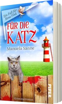 Das Buchcover zeigt einen hellblauen Himmel mit vereinzelten Wolken, über dem ein grauer Kater mit einer Krone auf dem Kopf thront. Im Hintergrund ist ein rot-weißer Leuchtturm zu sehen, der an einer grünen Wiese steht, vor der ein Holzzaun verläuft, auf dem rote Flecken abgebildet sind. Der Titel „FÜR DIE KATZ“ in großen, rot schimmernden Buchstaben dominiert das Cover, darunter stehen der Name der Autorin „Manuela Sanne“ sowie der Hinweis „Kriminalroman“.