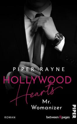 Das Buchcover zeigt einen eleganten Mann in einem Anzug, der mit einer Hand seine Krawatte adjustiert. Der Hintergrund ist in tiefem Schwarz gehalten, was eine geheimnisvolle Atmosphäre schafft. Der Titel „HOLLYWOOD Hearts“ ist in großen, pinken Buchstaben prominent platziert, während der Untertitel „Mr. Womanizer“ in schlichterer, weißer Schrift darunter steht. Der Autorname „Piper Rayne“ befindet sich am oberen Rand in Weiß. Das Cover vermittelt einen modernen, glamourösen Eindruck.