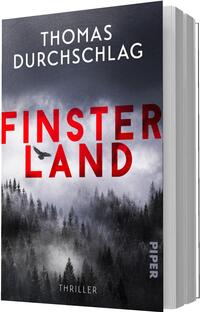 Das Buchcover zeigt eine düstere, nebelverhangene Nadelwald-Landschaft in Schwarz-, Grau- und Weißtönen; darüber der Autorenname Thomas Durchschlag in weißer Großschrift. Groß und auffällig in leuchtendem Rot die Titelzeile „Finsterland“, teilweise von einer schwarzen Vogelsilhouette überlagert. Typografie klar, serifenlos, kontrastreich. Unten kleingedruckt das Genre „Thriller“.