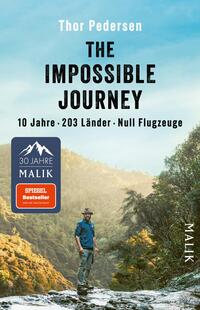 Das Buchcover zeigt eine Berglandschaft mit üppigem, grünem Bewuchs im Hintergrund. Im Vordergrund steht ein Mann in einem blauen Hemd und einer grauen Hose, der nachdenklich in die Ferne blickt. Der Titel „THE IMPOSSIBLE JOURNEY“ erscheint in großen, schwarzen Buchstaben, während die Untertitel „10 Jahre · 203 Länder · Null Flugzeuge“ in kleinerer Schrift darunter platziert sind. Der Name des Autors, Thor Pedersen, ist ebenfalls prominent oben auf dem Cover zu sehen. Die Gesamtatmosphäre vermittelt Abenteuerlust und Entdeckergeist.