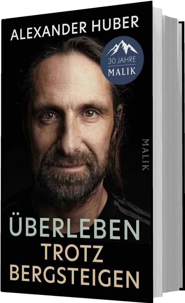 Das Buchcover zeigt ein großformatiges Porträt von Alexander Huber, halbnah, lichtbetont mit braunem Bart und zurückgebundenem Haar vor schwarzem Hintergrund. Oben steht der Autorname „ALEXANDER HUBER“ in weißer Großschrift; darunter der Titel „ÜBERLEBEN“ in mintgrün, gefolgt von „TROTZ BERGSTEIGEN“ in hellrosa/beige, beide groß und serifenlos. Die Stimmung wirkt ernst, nahbar und widerstandsfähig.