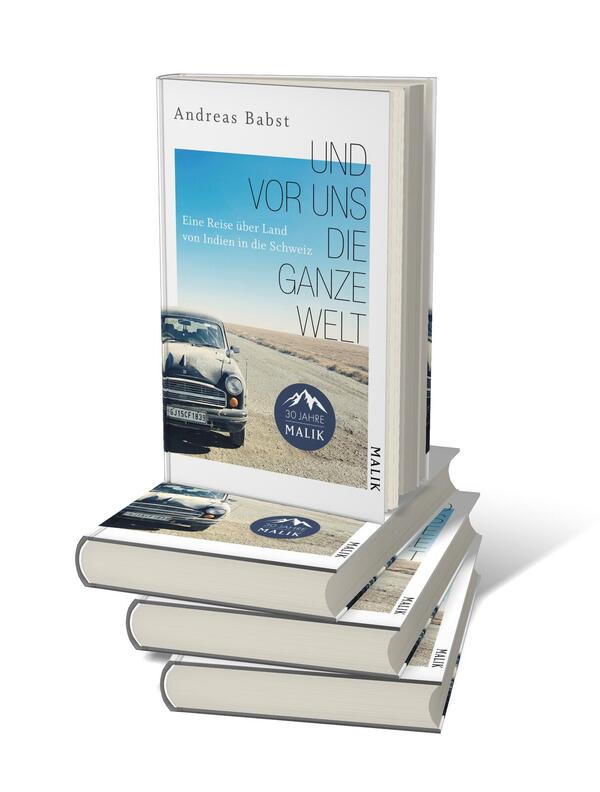Bücherstapel des Buches „Und vor uns die ganze Welt“