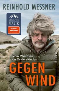 Das Buchcover zeigt ein Porträt von Reinhold Messner, der in einem gebräuntem Parka vor einer kargen Landschaft mit sanften Hügeln und einem Gewässer steht. Sein zerzaustes, graues Haar vermittelt eine Atmosphäre der Ungezwungenheit und Stärke. Der Titel „GEGEN WIND“ ist in auffälliger, orangefarbener Schrift in der unteren Mitte platziert, während der Untertitel „Vom Wachsen an Widerständen“ und der Verlag „MALIK“ in schlichterer Schrift darüber stehen.