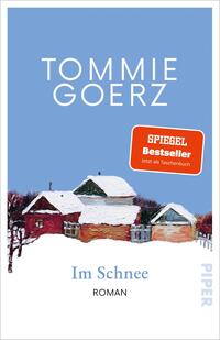 Das Buchcover zeigt einen hellblauen Himmel als Hintergrund, oben in großer weißer, serifenloser Versalien-Typografie der Autorenname TOMMIE GOERZ. Darunter eine leicht impressionistische Winterlandschaft mit roten Backsteinhäusern und schneebedeckten Dächern. Rechts ein oranger Button mit dem Text „SPIEGEL Bestseller Jetzt als Taschenbuch“. Titel „Im Schnee“ steht in gedecktem Blau in serifenbetonter Schrift, darunter klein „ROMAN“. Ruhige, winterliche Stimmung.