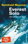 Das Buchcover zeigt eine eindrucksvolle, schneebedeckte Berglandschaft mit steilen Felsen und einem klaren blauen Himmel. Im Vordergrund ist ein Bergsteiger zu sehen, der den gesicherten Pfad hinaufsteigt. Der Titel „Everest Solo“ steht in großen weißen Buchstaben in der Mitte, während der Untertitel „Der gläserne Horizont“ in kleineren Anführungszeichen darunter platziert ist. Der Name des Autors, Reinhold Messner, ist in gelber Schrift oben aufgeführt. Die Gesamtatmosphäre vermittelt ein Gefühl von Abenteuer und Taubheit der Natur.