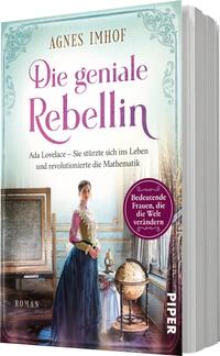 Das Buchcover zeigt eine junge Frau in historischer Kleidung, die frontal in den Betrachter blickt. Sie hat eine aufrechte Haltung und einen entschlossenen Ausdruck. Im Hintergrund sind ein Fenster und eine Tafel sichtbar. Die Farben sind pastellartig, mit dominierenden Blau- und Rosatönen. Der Titel „Die geniale Rebellin“ ist in eleganter, geschwungener Schrift in violett gehalten. Unter dem Titel findet sich der Untertitel „Ada Lovelace – Sie stürzte sich ins Leben und revolutionierte die Mathematik“. Das Verlagslogo befindet sich in der unteren Ecke. Ein runder Button kündigt an: „Bedeutende Frauen, die die Welt verändern“.