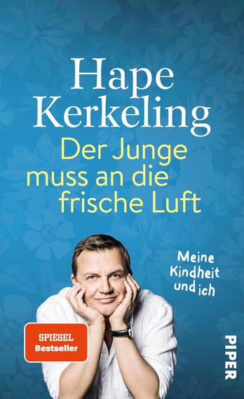 Das Buchcover zeigt einen hellblauen Hintergrund mit blumigem Muster. In der oberen Hälfte steht in großen, weißen Buchstaben der Name „Hape Kerkeling“. Darunter befindet sich der Titel „Der Junge muss an die frische Luft“ in gelbem Schriftzug. Am unteren Rand steht der Untertitel „Meine Kindheit und ich“ in kleinerer Schrift. Im Vordergrund ist ein lächelnder Mann mit kurzen, brünetten Haaren dargestellt, der seine Hände unter dem Kinn verschränkt. Unten links ist ein rotes Kästchen mit der Aufschrift „SPIEGEL Bestseller“ zu sehen.