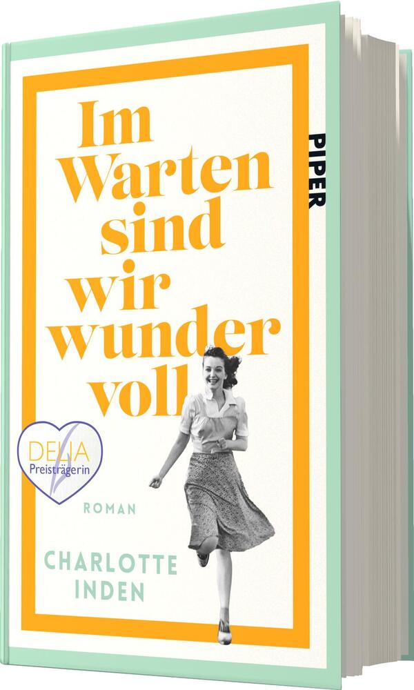 Das Buchcover zeigt einen dynamischen, fröhlichen Moment, in dem eine junge Frau in einem hellen, luftigen Kleid mit Lächeln läuft. Der Hintergrund ist in warmen Gelbtönen gehalten, umrahmt von einem weißen Rand. In der oberen Hälfte steht der Titel „Im Warten sind wir wundervoll“ in markanter, orangefarbener Schrift. Darunter ist der Text „Roman“ und der Name der Autorin „Charlotte Inden“ in schlichter, schwarzer Schrift platziert. Eine Auszeichnung in Form eines blauen Herzsymbols ist ebenfalls sichtbar.
