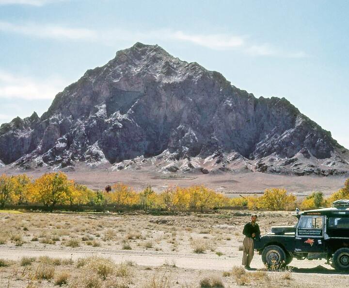 Land Rover vor einem Berg in der Wüste