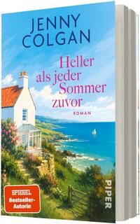 Das Buchcover zeigt eine helle Küstenszene mit weißem, giebeliges Haus und Glasveranda links im Vordergrund, blühende Sträucher und ein Pfad zum Meer rechts; weiter hinten Felsküste und ein Segelboot auf blauem Meer unter hellem, wolkigem Himmel. Oben groß: „JENNY COLGAN“, in der Mitte pinker Titel „Heller als jeder Sommer zuvor“, unten links rotes Label „SPIEGEL Bestseller-Autorin“.