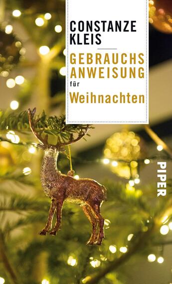 Das Buchcover zeigt einen festlich geschmückten Weihnachtsbaum mit goldenen und roten Ornamenten sowie glühenden Lichtern. Im Vordergrund hängt ein goldenes Rentier als Dekoration. Der Titel „GEBRAUCHSANWEISUNG für Weihnachten“ ist in auffälliger, goldfarbener Schrift auf weißem Hintergrund platziert. Der Name der Autorin „CONSTANZE KLEIS“ steht oben in Schwarz. Das Verlagslogo „PIPER“ befindet sich am unteren rechten Rand in Weiß. Die gesamte Gestaltung vermittelt eine warme, einladende Weihnachtsatmosphäre.