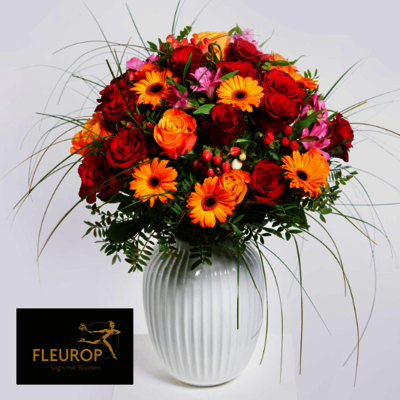 bunter Blumenstrauß in einer weißen Vase. Unten links ist das Logo von 'Fleurop' zu sehen