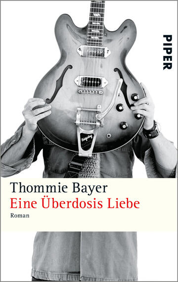 Das Buchcover zeigt eine schwarz-weiße Darstellung einer Person, die eine elektrische Gitarre vor dem Gesicht hält. Der Titel „Eine Überdosis Liebe“ ist in roter Schrift hervorgehoben, während der Autorenname „Thommie Bayer“ in schwarzer Schrift darüber steht. Der Hintergrund ist schlicht und unauffällig, was die Aufmerksamkeit auf die zentrale Figur und die Gitarre lenkt. Im oberen rechten Bereich ist das Wort „PIPER“ in blauer Schrift zu sehen. Die Gesamtatmosphäre vermittelt eine Mischung aus Melancholie und Musikleidenschaft.
