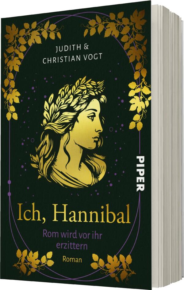 Das Buchcover zeigt eine goldene Illustration eines weiblichen Gesichts mit einem Lorbeerkranz, umgeben von stilisierten Pflanzenmotiven in gold auf einem dunklen, nahezu schwarzen Hintergrund. Der Titel „Ich, Hannibal“ ist in eleganter, geschwungener Schrift in goldenen Buchstaben platziert, während die Autorennamen „Judith & Christian Vogt“ in weißer Schrift am oberen Rand stehen. Im unteren Bereich des Covers ist der Hinweis „Roman“ in schlichter Schrift zu sehen. Die Gesamtatmosphäre vermittelt eine geheimnisvolle und historische Stimmung.