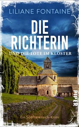 Die Richterin und die Tote im Kloster Das Buchcover zeigt eine malerische Klosteranlage inmitten einer grünen Landschaft unter einem klaren blauen Himmel. Im Vordergrund ist der Eingang des Klosters zu sehen, umgeben von sanften Hügeln und Nadelbäumen. Der Titel „DIE RICHTERIN“ steht in großen, weißen Buchstaben im oberen Bereich, während der Untertitel „und die tote im Kloster“ in einer kleineren Schrift darunter erscheint. Der Name der Autorin, Liliane Fontaine, ist ebenfalls platziert. Die Gesamtatmosphäre vermittelt eine mysteriöse und spannende Stimmung.